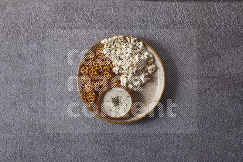 Assorted snacks in pottery bowls on grey background