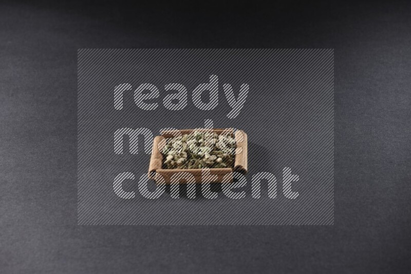 A single square of cinnamon sticks full of Cardamom on black flooring