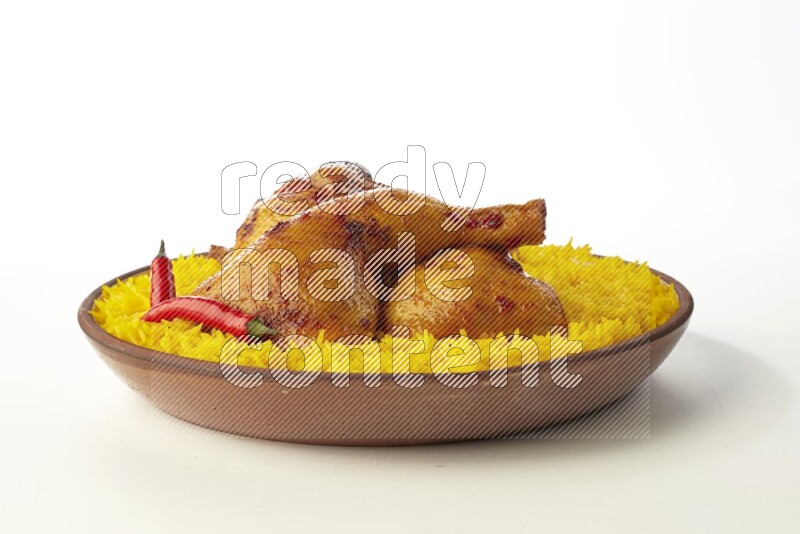 yellow basmati Rice with kabsa chicken pieces on a pottery plate direct on white background