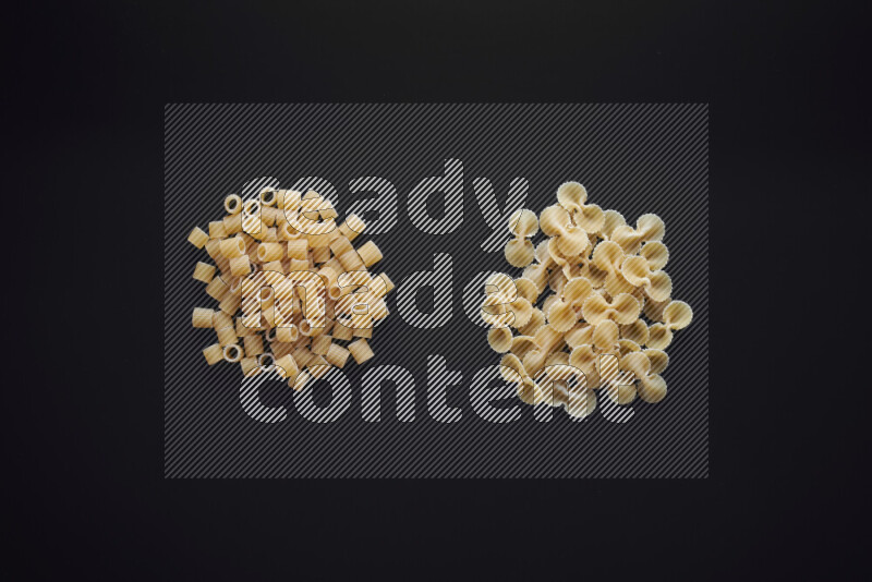 Different pasta types in bunches on black background