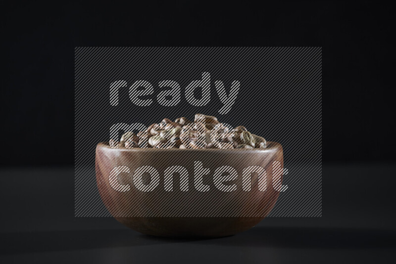 Fava beans in a wooden bowl on grey background