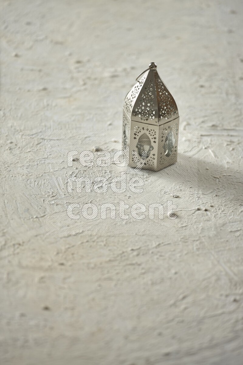 A lantern placed on a textured white background