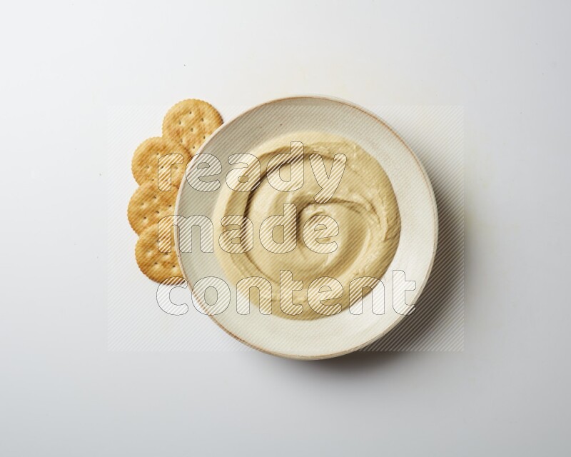 plain Hummus in a pottry plate  on a white background