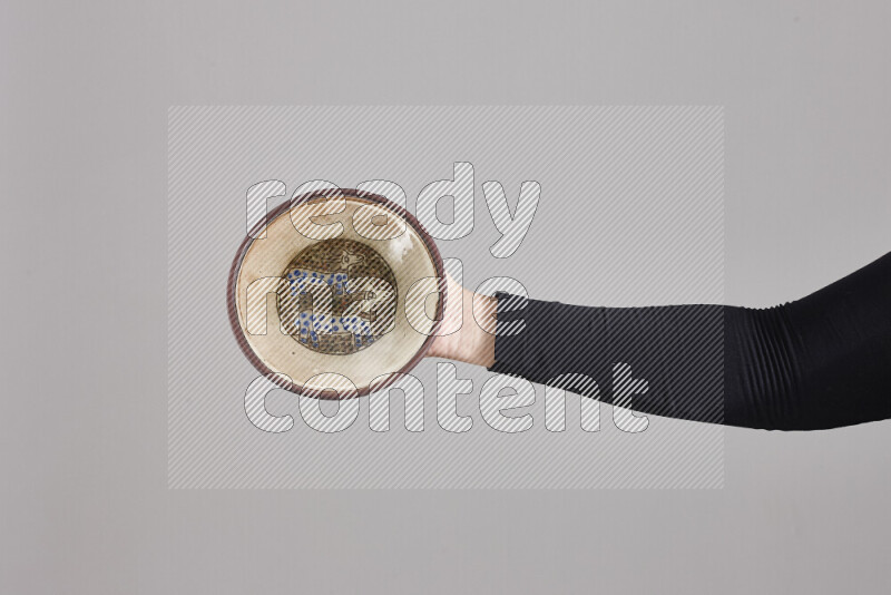 A woman in black abaya holding different pottery essentials in different positions