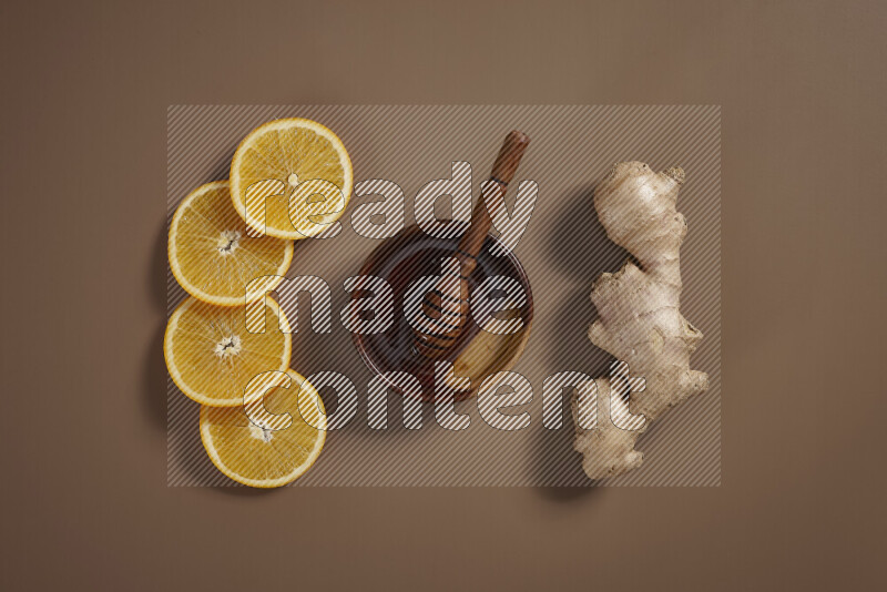 Fresh ginger root with different ingredients such as lemon, orange, honey, ground ginger on beige baackground