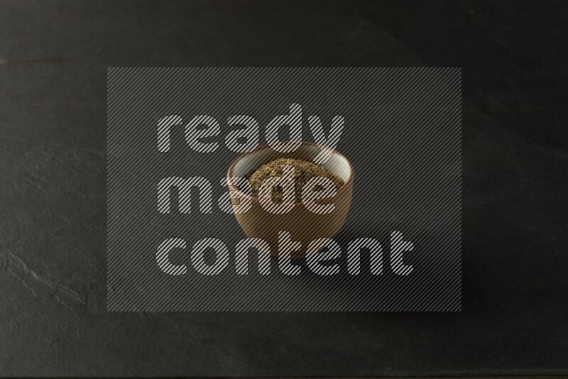 multi color round sauce bowl filled with herbs on grey textured countertop