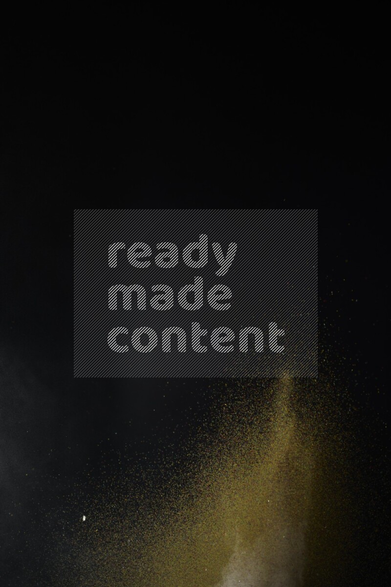 A side view of brown powder explosion on black background