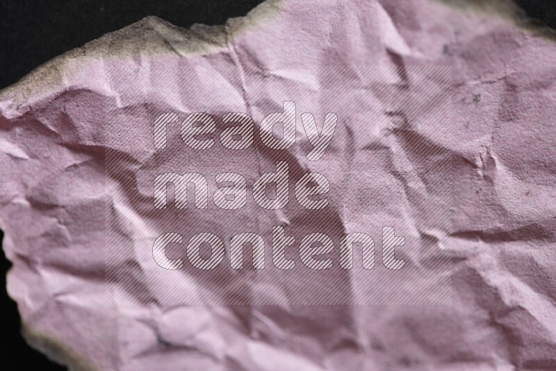 Burnt multicolored paper on black background