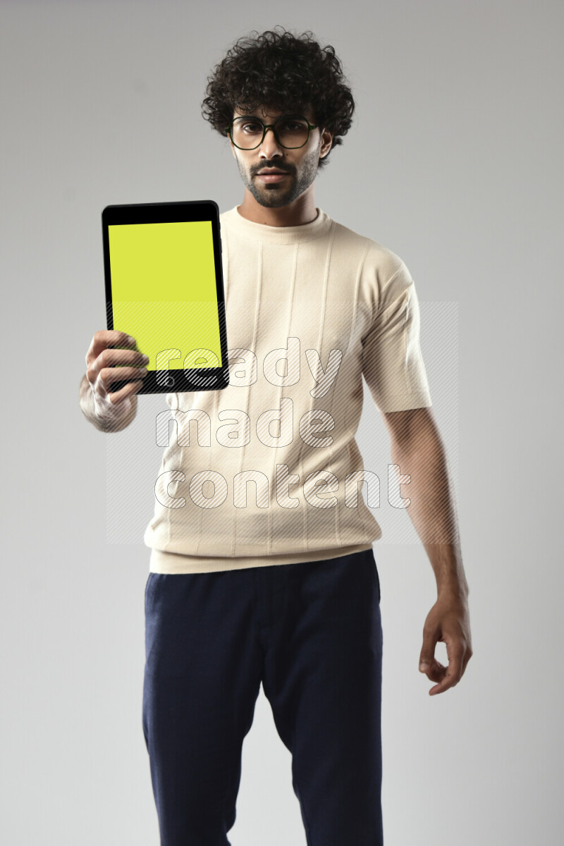 A man wearing casual standing and showing a tablet screen on white background