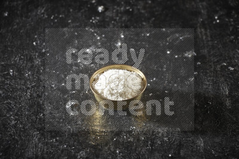 Dried fruits in a metal bowl in a dark setup
