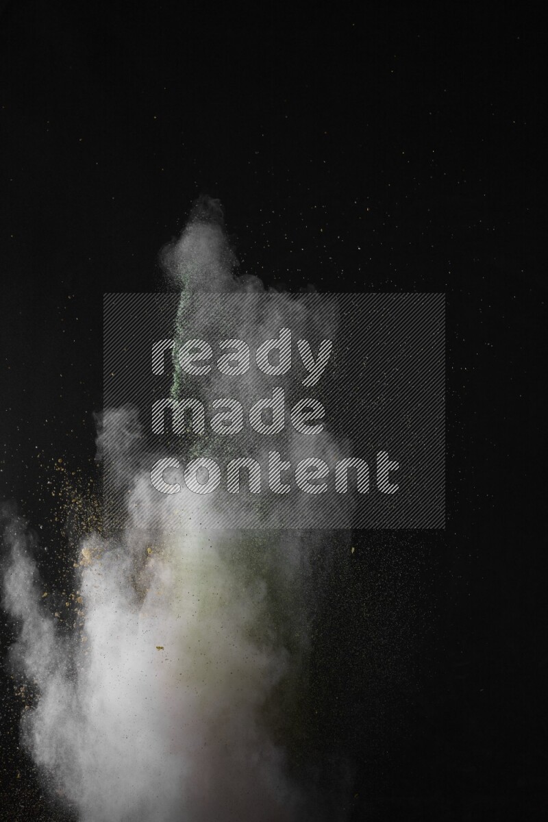 A side view of multicolored powder explosion on black background