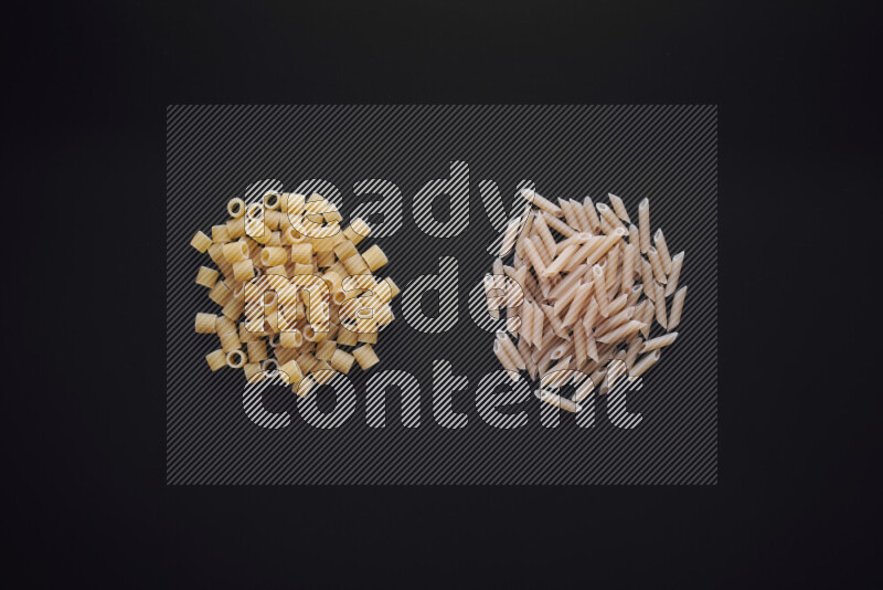 Different pasta types in bunches on black background