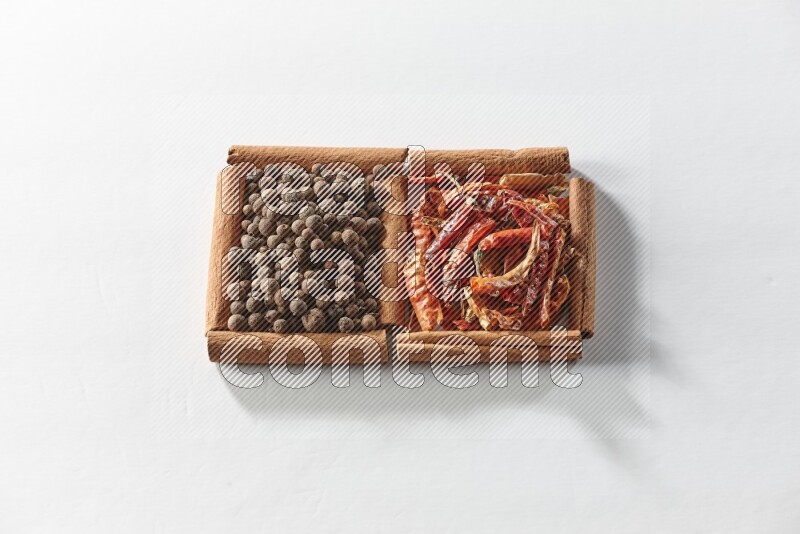 2 squares of cinnamon sticks full of dried red chilis and allspice on white flooring