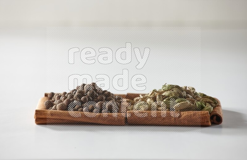 2 squares of cinnamon sticks full of cardamom and allspice on white flooring
