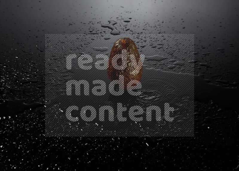 A whole avocado on black background with water drops.