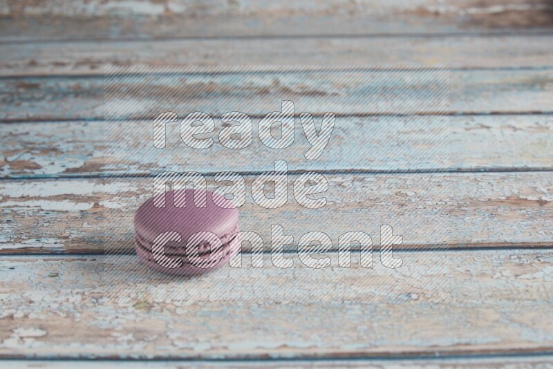 45º Shot of Purple Blueberry macaron on light blue wooden background