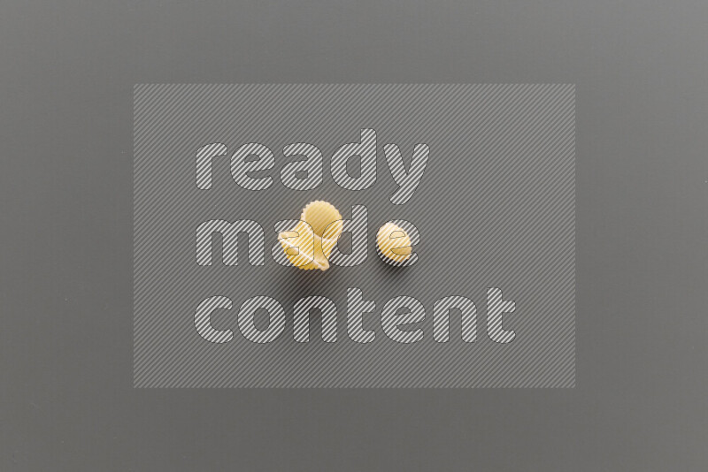 Pipe pasta with other types of pasta on grey background