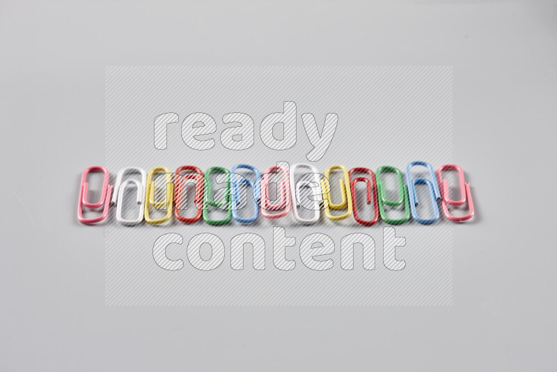 Multicolored paper clips isolated on a grey background