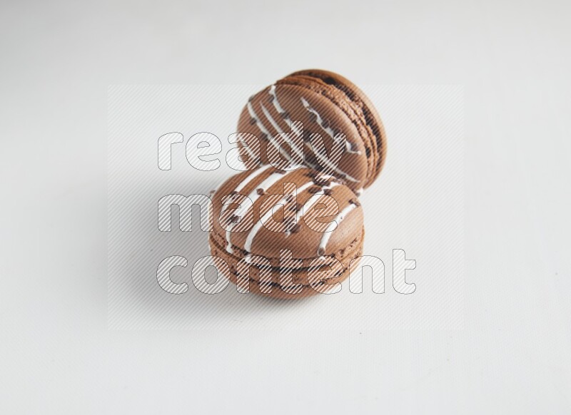 45º Shot of two Brown white Chocolate Caramel macarons on white background