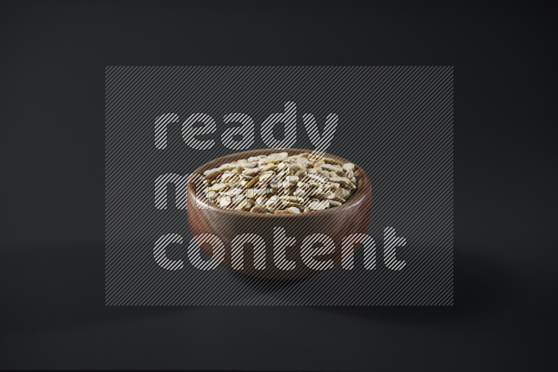 Crushed beans in a wooden bowl on grey background