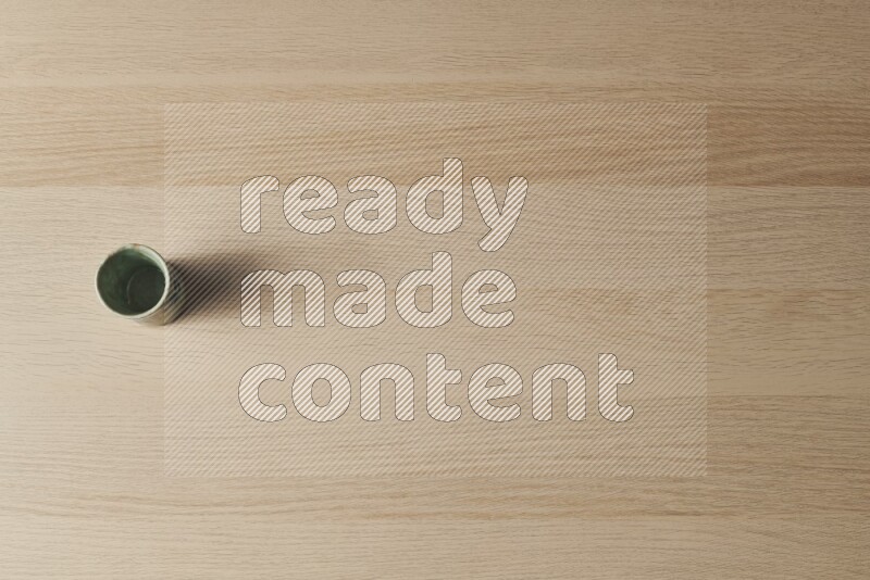 A pottery cup on light wooden background