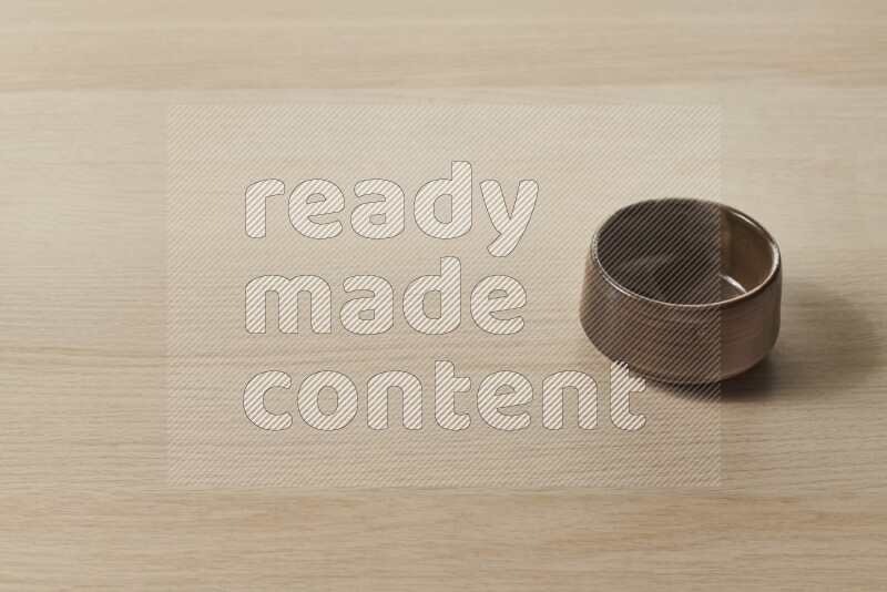 A multicolored pottery bowl on light wooden background