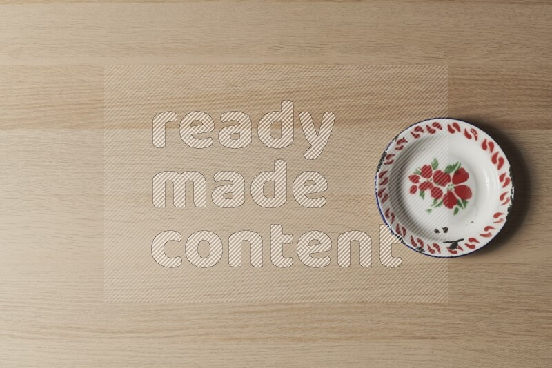 A vintage metal plate on light wooden background