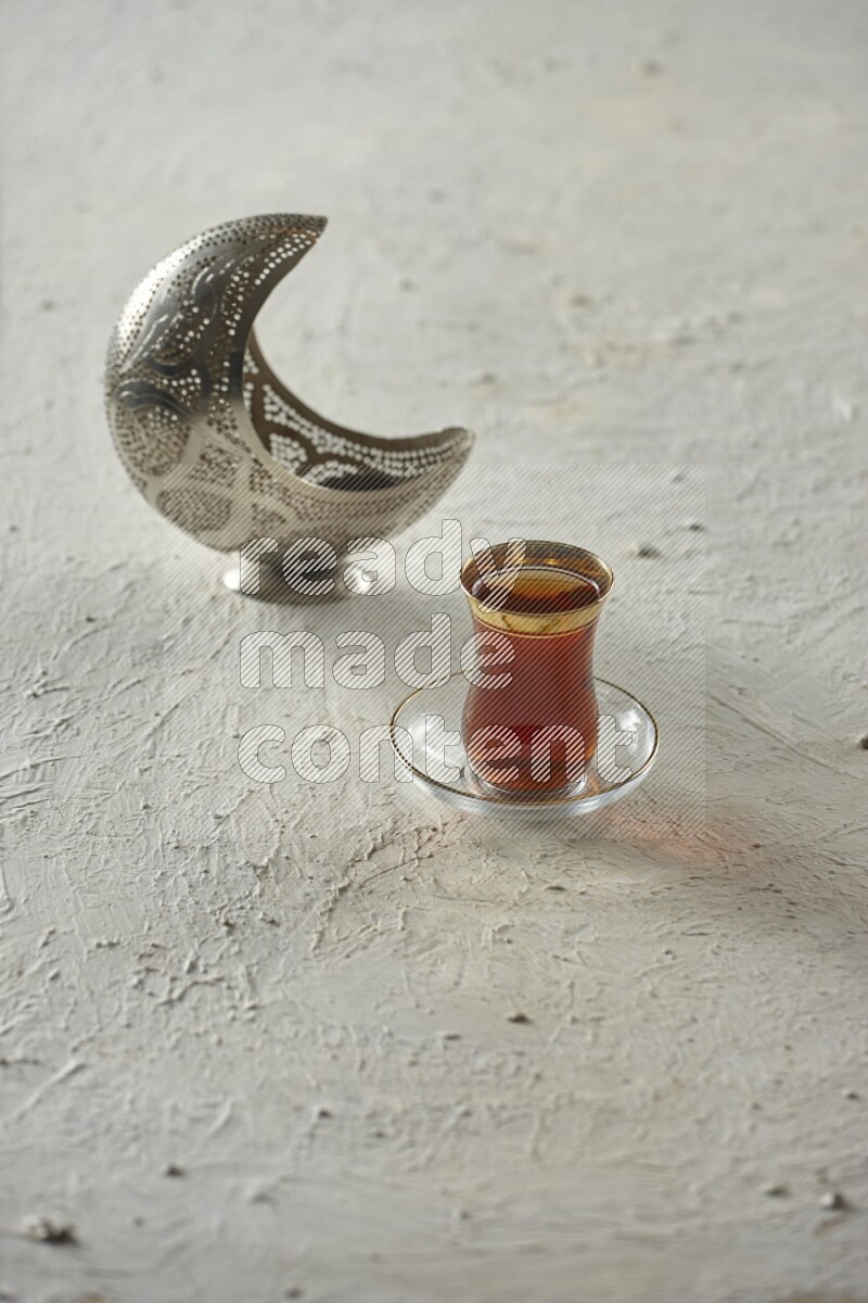 A silver lantern with different drinks, dates, nuts, prayer beads and quran on textured white background