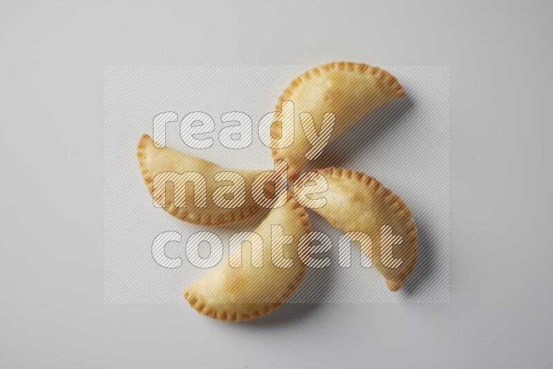 Four fried sambosa from a top angle on a white background