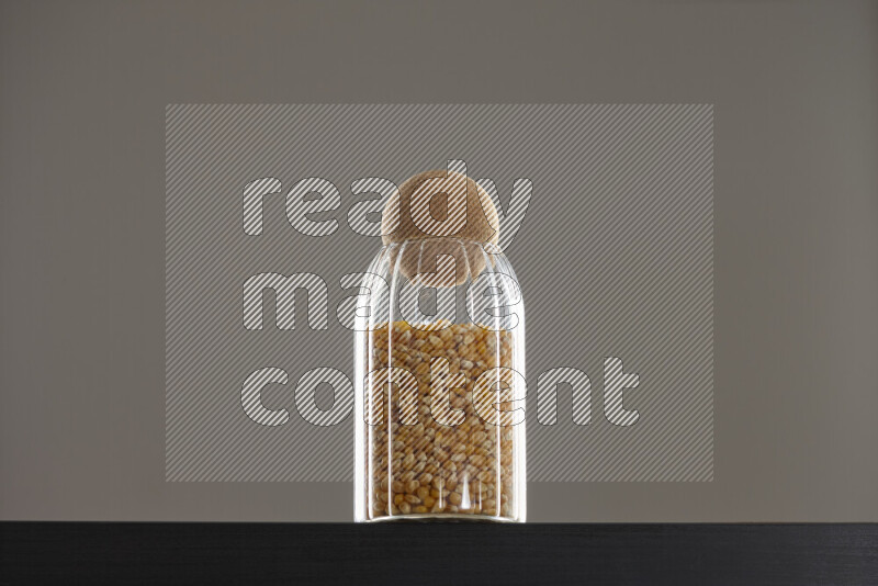 Pop corn in a glass jar on black background