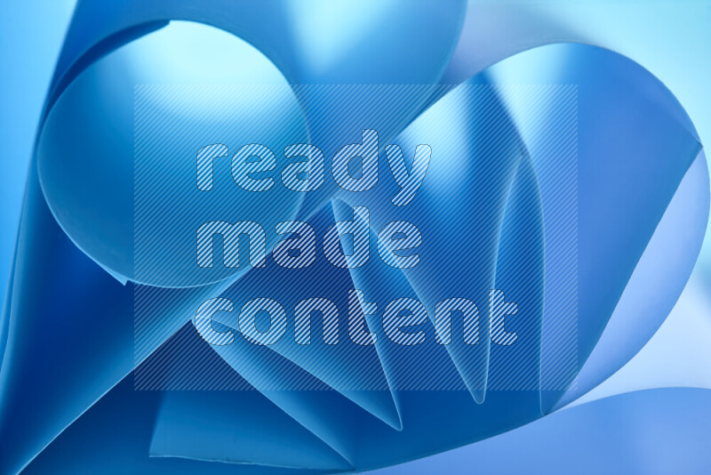 An artistic display of paper folds creating a harmonious blend of geometric shapes, highlighted by soft lighting in blue tones