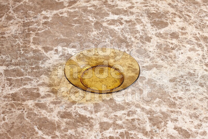 A circular glass plate on beige marble background