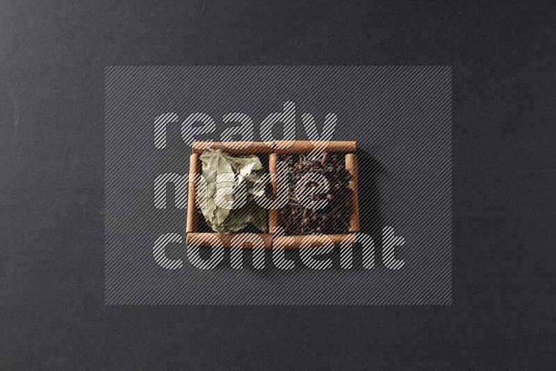 2 squares of cinnamon sticks full of cloves and bay laurel leaves on black flooring