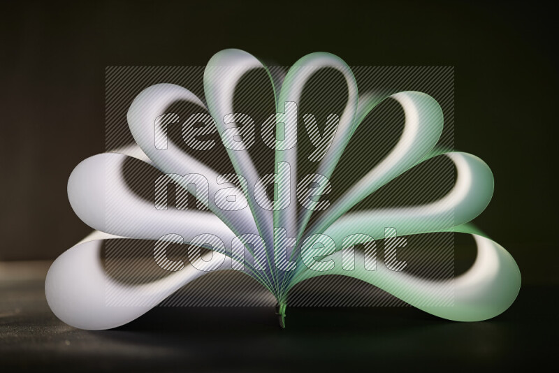 An abstract art piece displaying smooth curves in green and white gradients created by colored light