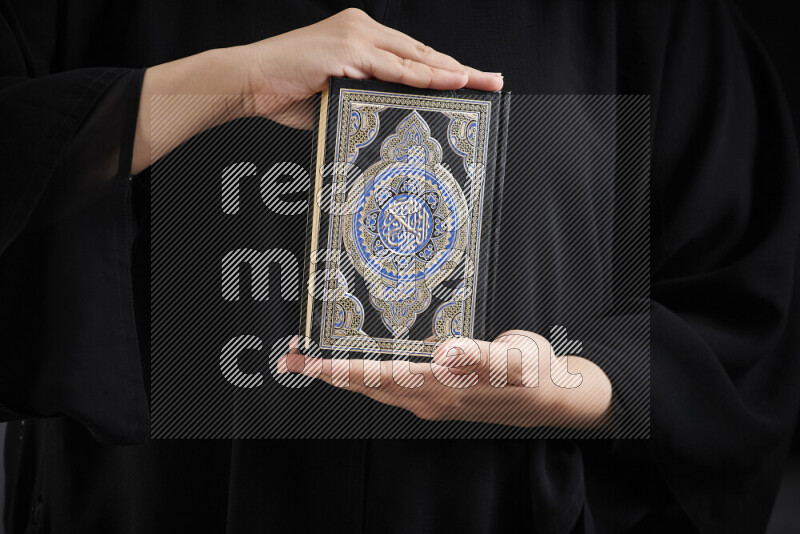 امرأة تحمل بيديها مصحف القرآن في أوضاع متعددة