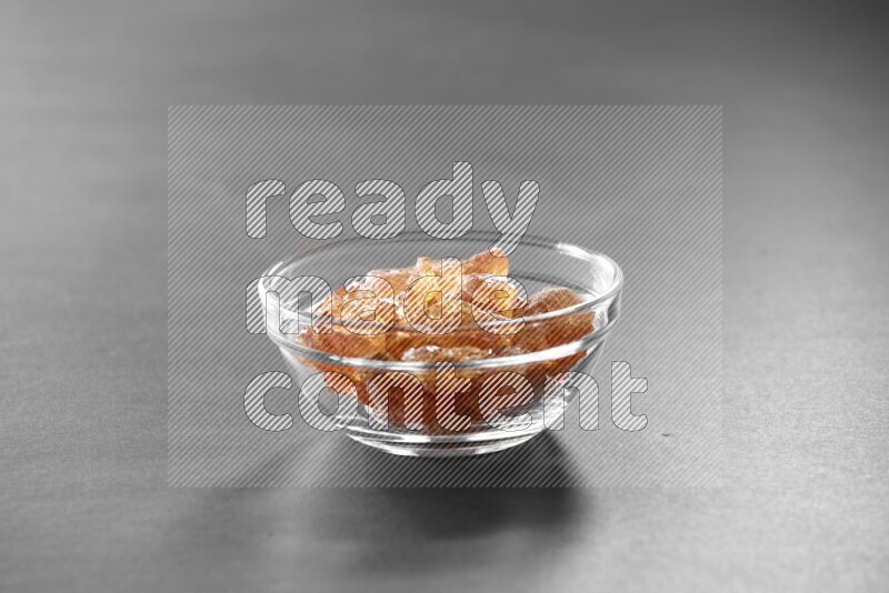 A glass bowl full of gum arabic on black flooring