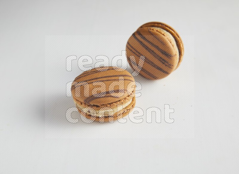 45º Shot of two light brown  Almond Cream macarons on white background