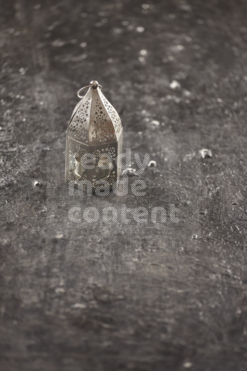 A lantern placed on a textured black background