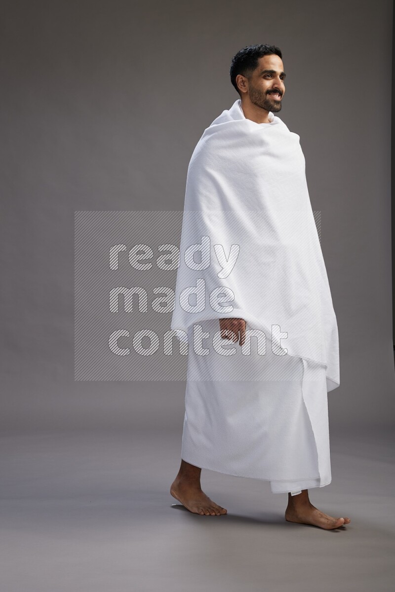 A man wearing Ehram Standing Interacting with the camera on gray background