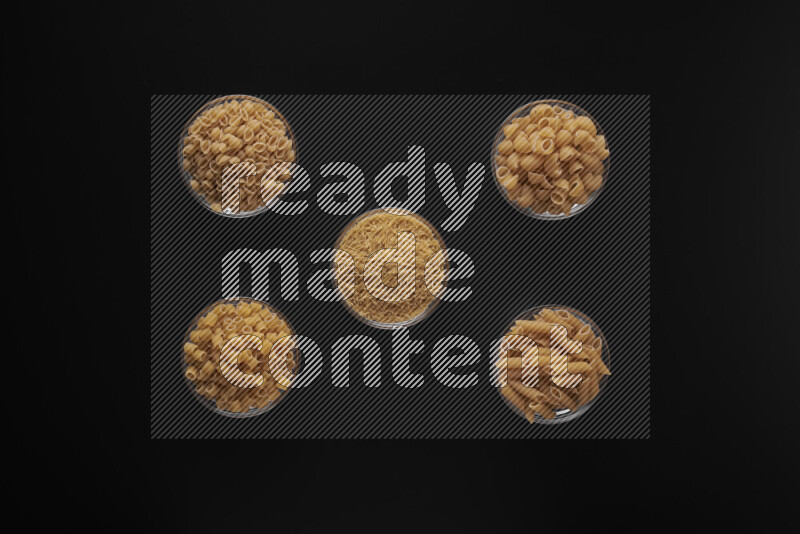 أنواع مختلفة من المعكرونة في أوعية زجاجية علي خلفية سوداء