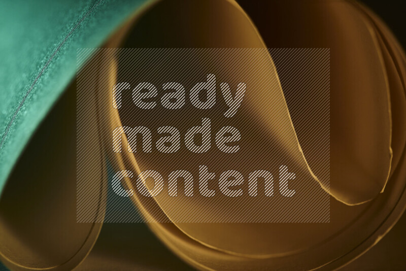 An abstract art piece displaying smooth curves in green and orange gradients created by colored light