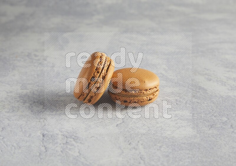 45º Shot of two Brown Maple Taffy macarons  on white  marble background