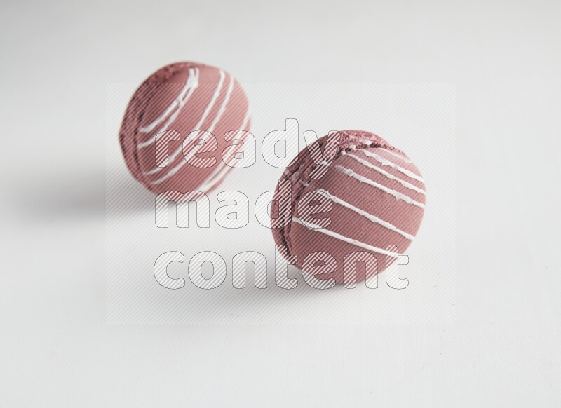 45º Shot of two Red Poppy Flower macarons on white background