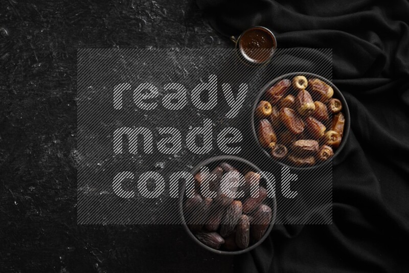Dates in pottery bowls with coffee in a dark setup