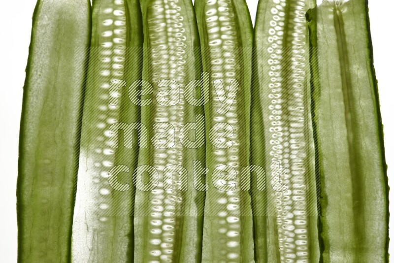 Cucumber slices on illuminated white background