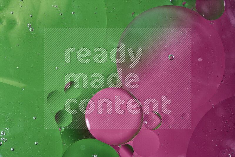 لقطات مقربة لفقاعات من الزيت على سطح الماء باللون الأخضر والوردي