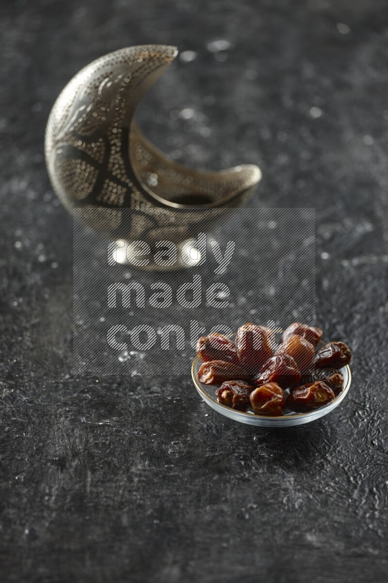 فانوس فضي مع مشروبات مختلفة وتمر ومكسرات وسبحة صلاة وقرآن على خلفية سوداء