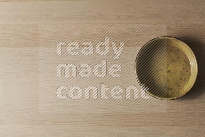 A multicolored pottery oven plate on light wooden background