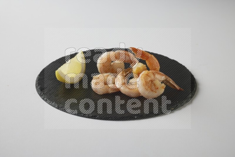 five grilled shrimps  on a black slate direct  on a white back ground
