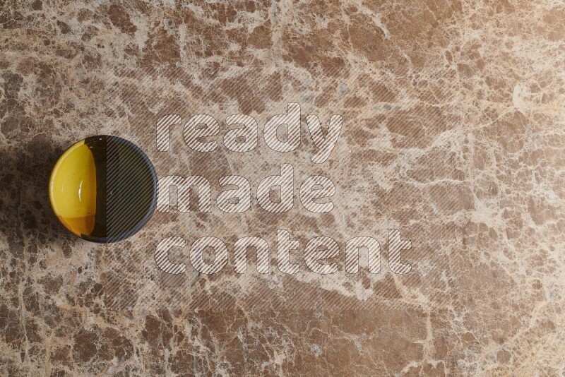 A multicolored pottery bowl on beige marble background